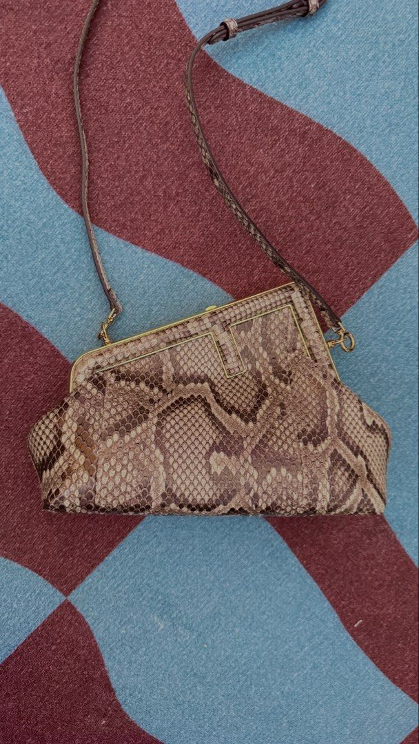 Fendi Python Clutch Bag (Category: Clutches) located in Singapore. Submitted by jkonlysellgenuine (Listing ID 1458348228, Image 2). Description: - Authentic Fendi clutch - Genuine python skin - Gold hardware frame closure - Fendi logo lining interior - Detachable strap included - Ideal for evenings out or special occasions - Unique texture and design.