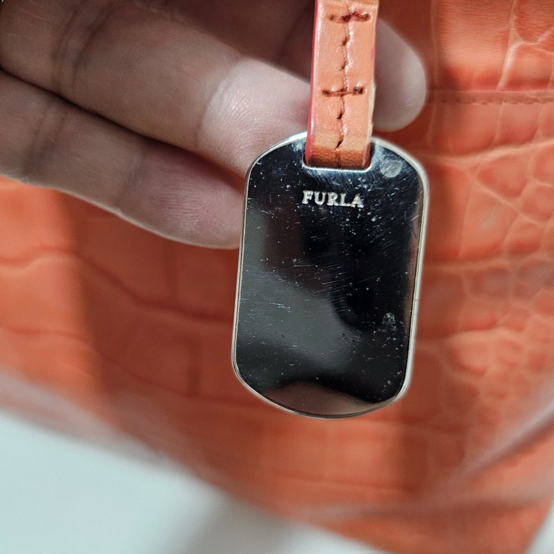 Furla Orange Croc Embossed Leather Top Handle Bag (Category: Luxury Bags & Wallets) located in Paranaque City. Submitted by ysabelsbag (Listing ID 1458478152, Image 2). Description: - Authentic Furla handbag in a vibrant orange hue. - Luxurious croc-embossed leather finish. - Versatile carrying options: top handles and a detachable shoulder strap. - Elegant silver-tone hardware. - Protective metal studs on the bottom to prevent wear. - Dimensions