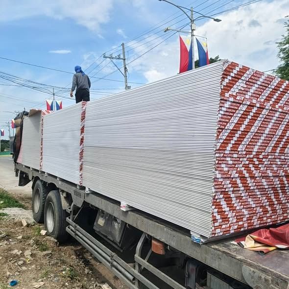 Gypsum Board Drywall Sheets for Construction (Category: Construction & Building Materials) located in Quezon City. Submitted by takeitorleaveitshop (Listing ID 1458477928, Image 1). Description: - Bulk supply of gypsum drywall boards - Ideal for interior wall and ceiling construction - Stacked high on truck, ready for delivery - Standard white finish - Red and white patterned edges.