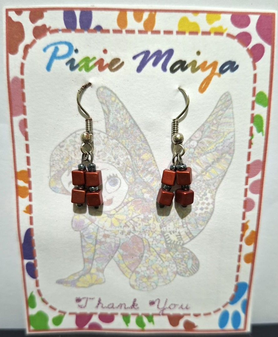 Handmade Red Cube Bead Dangle Earrings (Category: Earrings) located in Valenzuela. Submitted by pixieworks64309 (Listing ID 1458325123, Image 1). Description: - Handmade earrings - Features red cube beads and small grey accent beads - Silver-tone fishhook ear wires - Displayed on a charming fairy illustration card ('Pixie Maiya', 'Thank You') - Perfect for adding a pop of color to your look.