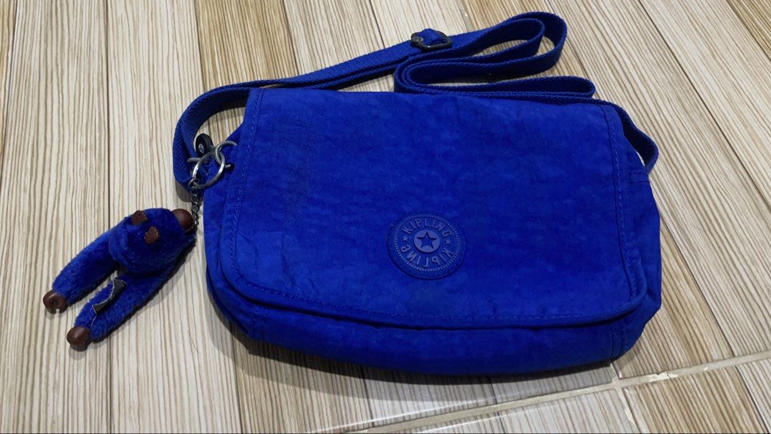 Kipling Delphin N Cross-Body Bag (Category: Cross-body Bags) located in Dasmarinas. Submitted by takarabox (Listing ID 1458471504, Image 1). Description: The Kipling Delphin N Cross-Body Bag is a highly organized, lightweight everyday bag praised for its practical hands-free design. This compact bag features a signature fold-over flap with a secure snap closure, hiding an efficiently compartmentalized interior crafted from water-repellent crinkle