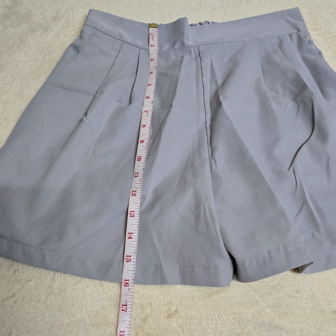 Light Gray Pleated Shorts (Category: Shorts) located in Pasay City. Submitted by fruityorange (Listing ID 1458381135, Image 3). Description: Color: Light Gray Size: Adjustable waistband (Max stretch: 20 inches, see photo) Material: Soft, breathable fabric (likely cotton blend) Design: Pleated skirt style with elastic waistband and flowy hem Condition: Pre-loved, gently used Measurements: Approx. 17 inches across waistband (see photos for accuracy