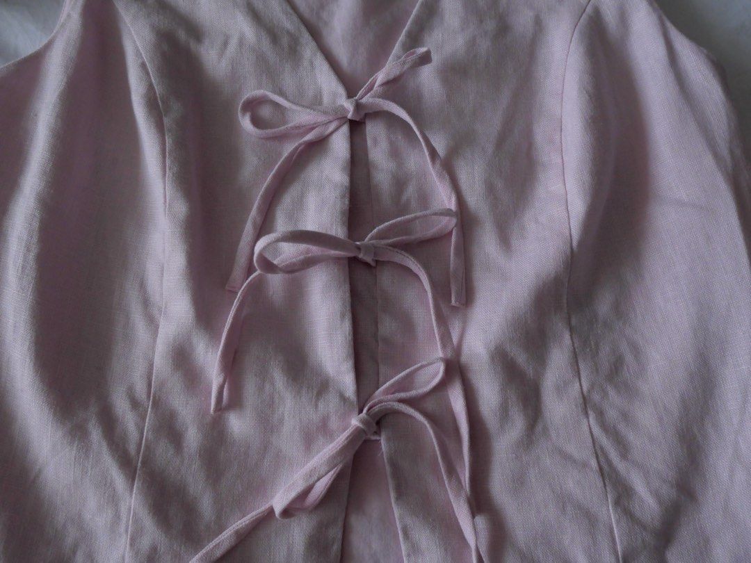 Light Pink V-Neck Vest with Tie Front (Category: Sleeveless) located in Manila. Submitted by preloved.shan1a (Listing ID 1458429847, Image 2). Description: - Fits Semi Med -Cute light pink vest - V-neckline with front tie-up detail - Sleeveless design - Ideal for layering or wearing on its own - Easily styled for casual or dressy looks.