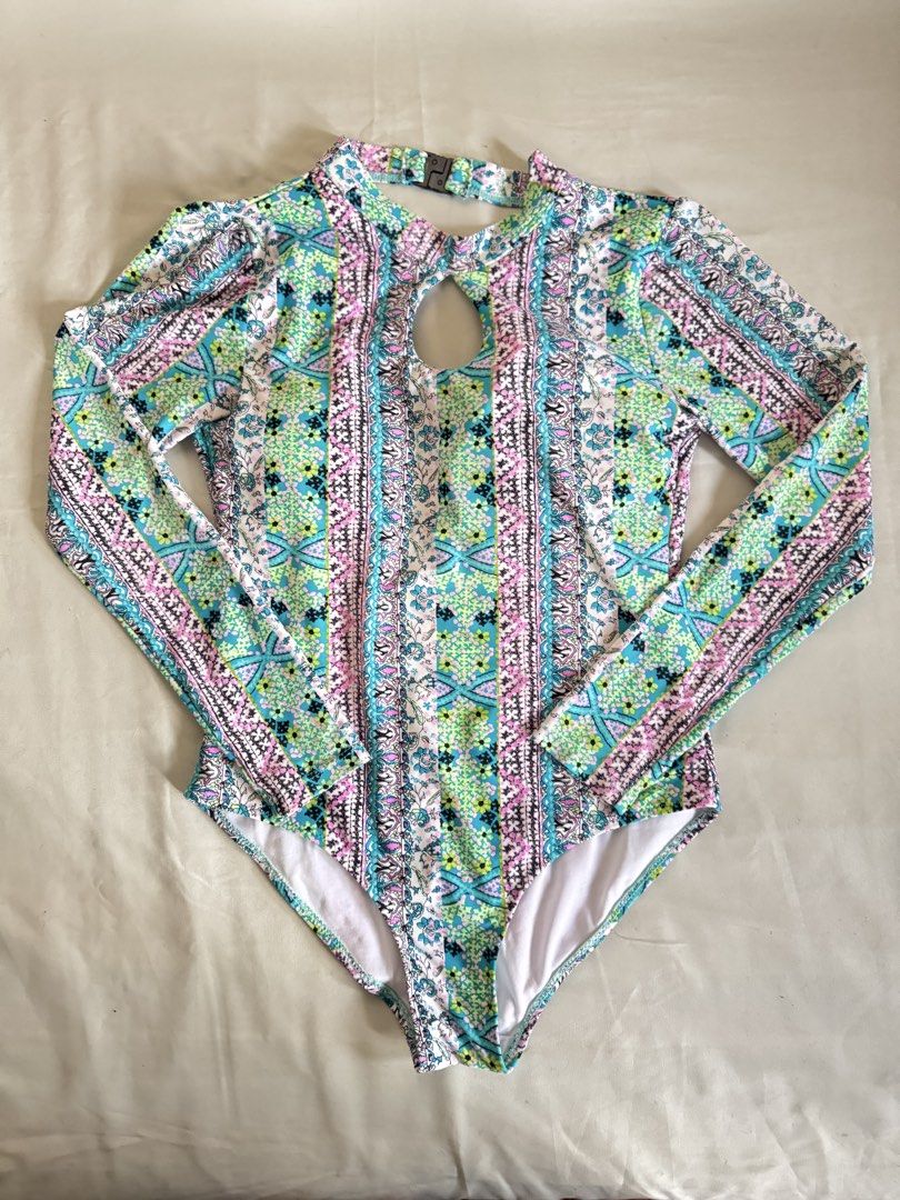 Long Sleeve Cut-Out Print One-Piece Swimsuit (Category: Bikinis & Swimsuits) located in Baguio. Submitted by makemegeli (Listing ID 1458324421, Image 1). Description: Long sleeve one-piece swimsuit with a colorful geometric and floral print. Features a cut-out detail at the chest and a high neckline. Back has a keyhole opening. Great for sun protection while swimming or at the beach. Comfortable and stylish design..