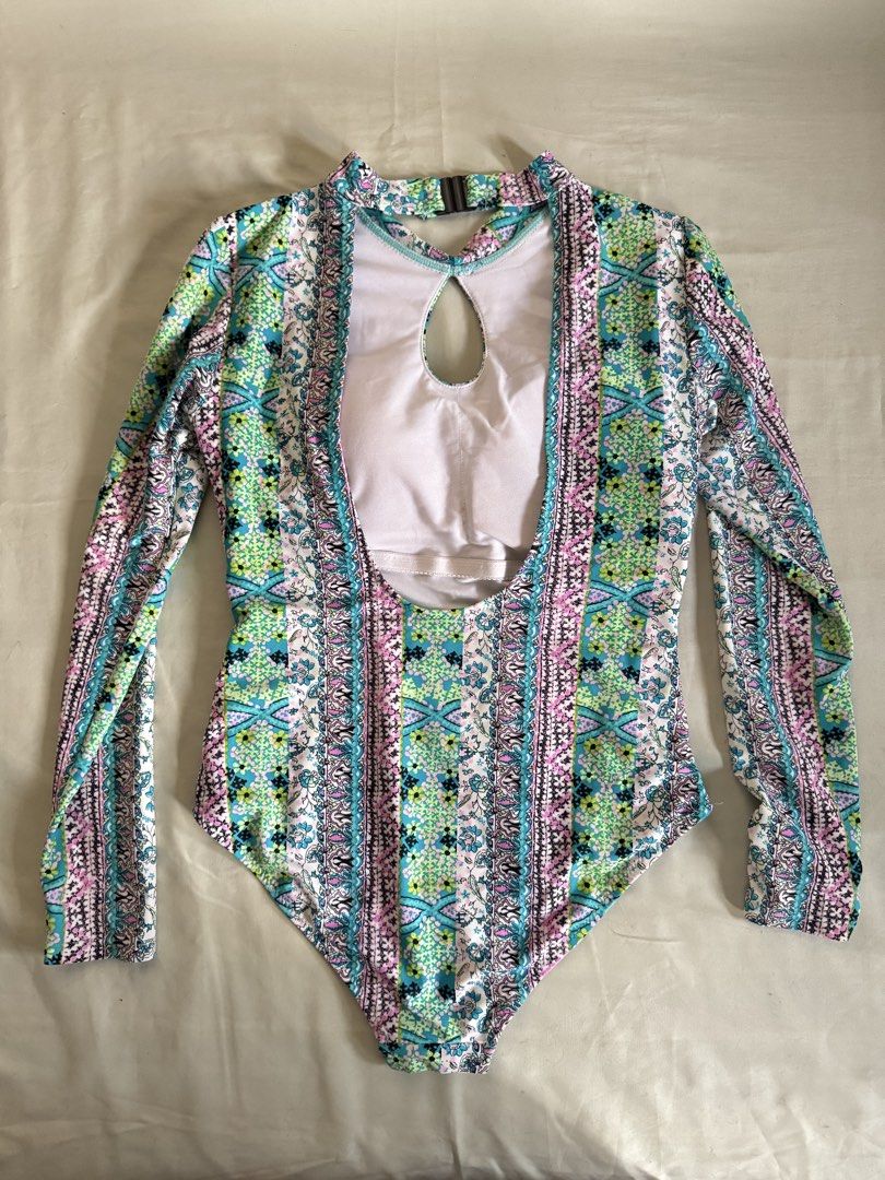 Long Sleeve Cut-Out Print One-Piece Swimsuit (Category: Bikinis & Swimsuits) located in Baguio. Submitted by makemegeli (Listing ID 1458324421, Image 2). Description: Long sleeve one-piece swimsuit with a colorful geometric and floral print. Features a cut-out detail at the chest and a high neckline. Back has a keyhole opening. Great for sun protection while swimming or at the beach. Comfortable and stylish design..