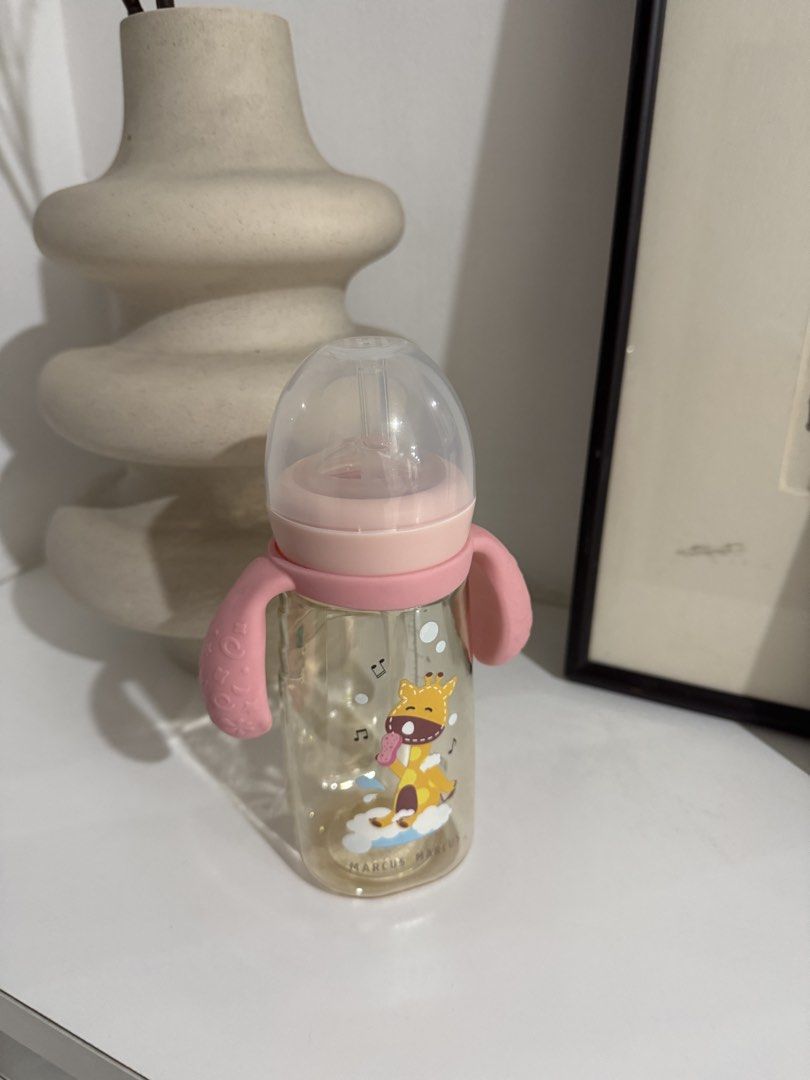 Marcus & Marcus Baby Bottle with Handles (Category: Breastfeeding & Bottle Feeding) located in Quezon City. Submitted by heylouise (Listing ID 1458425445, Image 1). Description: - Adorable baby bottle featuring a cute giraffe design. - Comes with convenient easy-grip handles for little hands. - Features charming pink accents on the lid and handles. - Clear measurement markings on the side for precise feeding. - Ideal for feeding your baby or todd