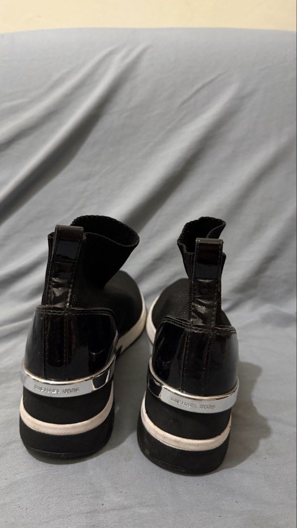 Michael Kors Black Sock Sneakers (Category: Sneakers) located in Cavite. Submitted by maxs.bl (Listing ID 1458353825, Image 2). Description: - Brand: Michael Kors - Style: Sock Sneakers - Color: Black - Design: Slip-on with comfortable knit upper - Details: MK logo on front, "Michael Kors" on back heel - Sole: White with black trim - Occasion: Perfect for casual outings.