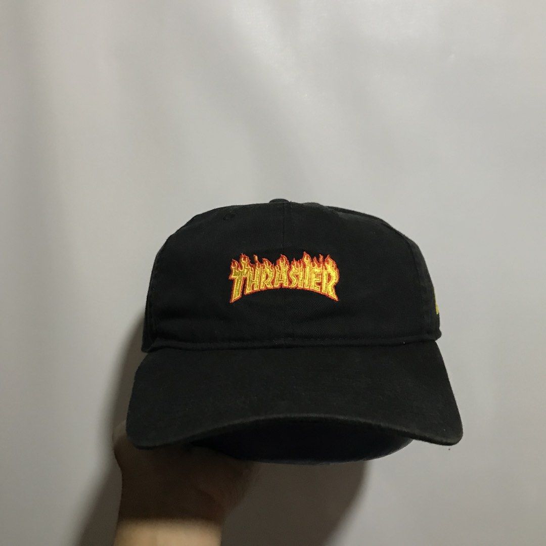 New Era x Thrasher Flame Logo Dad Cap Black (Category: Caps & Hats) located in Manila. Submitted by matias_10sstwr (Listing ID 1458326338, Image 1). Description: - Brand: New Era - Design: Black dad cap with embroidered Thrasher flame logo on front - Features: New Era logo on side, adjustable strap at back - Material: 100% Cotton - Style: Casual, everyday wear.