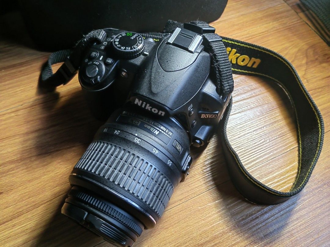 Nikon D3100 DSLR Camera with Lens (Category: Cameras) located in Quezon City. Submitted by abeharvestmoon27 (Listing ID 1458357113, Image 1). Description: - Nikon D3100 DSLR camera - Ideal for beginner photographers - Includes kit lens - Low shutter count - personal use only, still fresh - Still in good working condition - Comes with Nikon strap and lens cap - Includes a camera bag, wall charger, rubber lens cap, external mic, flash cables etc.. 