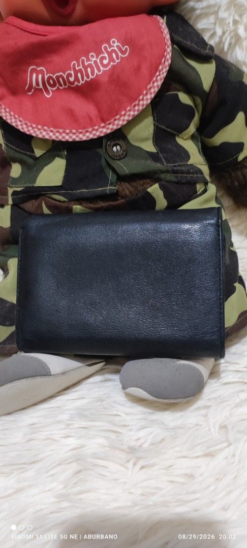 Nina Ricci wallet (Category: Wallets & Card holders) located in Makati City. Submitted by yerbua103 (Listing ID 1458423987, Image 2). Description: This is a vintage Nina Ricci with black textured leather flap wallet featuring a gold-tone half-moon metal hardware logo plaque on the front snap closure. Manage your expectations as you're buying a preloved/ukay wallet. Disclaimer: No copyright/ infringement is intended. the brand belongs to the right