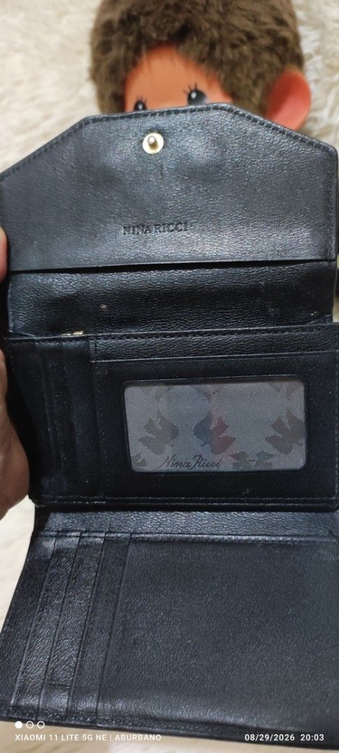 Nina Ricci wallet (Category: Wallets & Card holders) located in Makati City. Submitted by yerbua103 (Listing ID 1458423987, Image 3). Description: This is a vintage Nina Ricci with black textured leather flap wallet featuring a gold-tone half-moon metal hardware logo plaque on the front snap closure. Manage your expectations as you're buying a preloved/ukay wallet. Disclaimer: No copyright/ infringement is intended. the brand belongs to the right