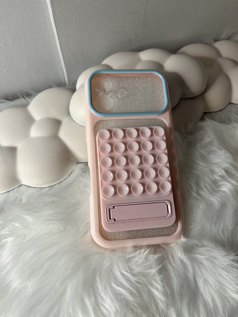 Pink Phone Case with Pop It and Stand for iphone 17 base (Category: Cases & Sleeves) located in Quezon City. Submitted by airamxxxthings (Listing ID 1458361537, Image 1). Description: - Adorable pink phone case - Integrated pop-it fidget toy for stress relief - Built-in kickstand for convenient viewing - Provides stylish protection for your phone.