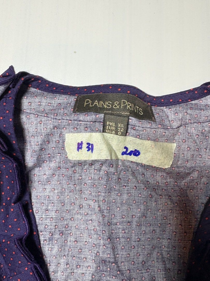 Plains & Prints Navy Polka Dot Ruffled Sleeveless Top (Category: Sleeveless) located in Baguio. Submitted by cosmogyralfinds (Listing ID 1458326639, Image 2). Description: - Navy blue sleeveless top - Pink polka dot pattern - Ruffled neckline - Button-down front - Cinched waist for a flattering fit - Brand: Plains & Prints - Ideal for casual or dressed-up looks.