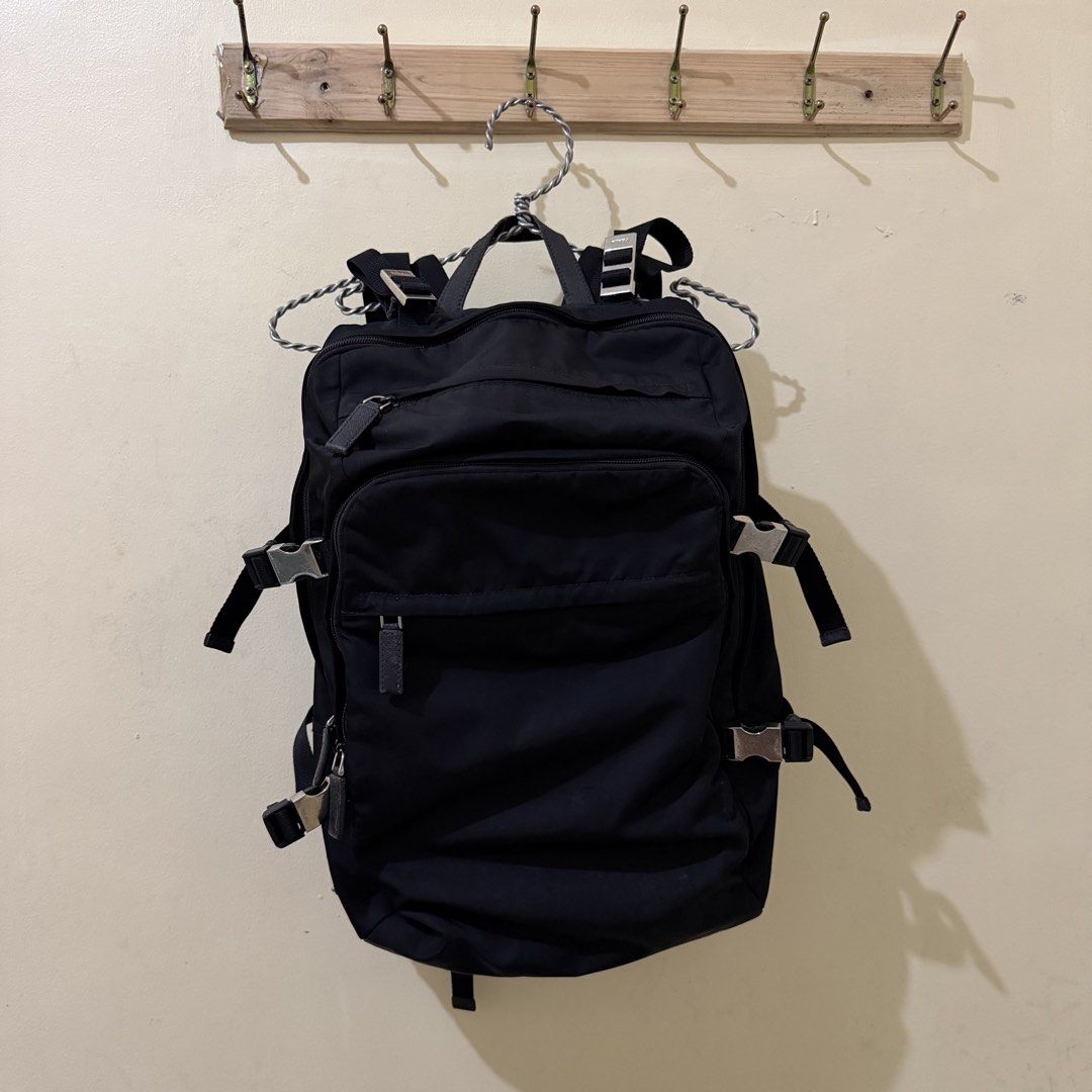 Prada Nylon Backpack Black (Category: Luxury Bags & Wallets) located in Tiwi. Submitted by demabubut (Listing ID 1458409684, Image 1). Description: - Authentic Black Prada Backpack - Made of durable nylon material - Multiple zip pockets for organized storage - Secure buckle closures - Iconic Prada logo prominently displayed on the front - Minor wear on zipper pulls and buckles, adding character - Ideal for everyday use and travel.