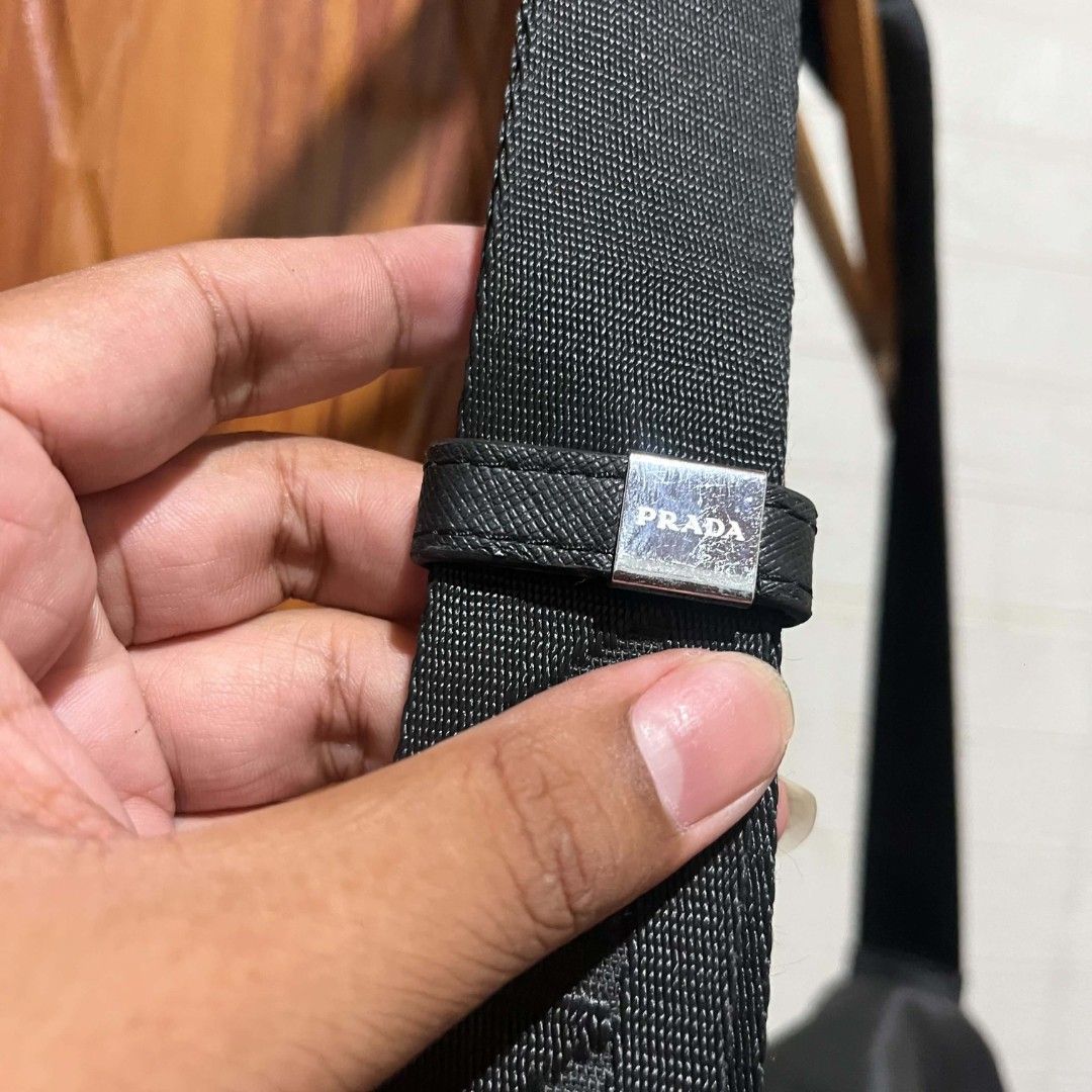 Prada Nylon Messenger Bag Black (Category: Luxury Bags & Wallets) located in Manila. Submitted by abj_thriftshop (Listing ID 1458448989, Image 2). Description: - Prada messenger bag - Color: Black - Material: Nylon with leather trim - Features: Adjustable strap with Prada logo, front flap buckle closure - Interior detail: Tag with '175' - Ideal for: Everyday use.