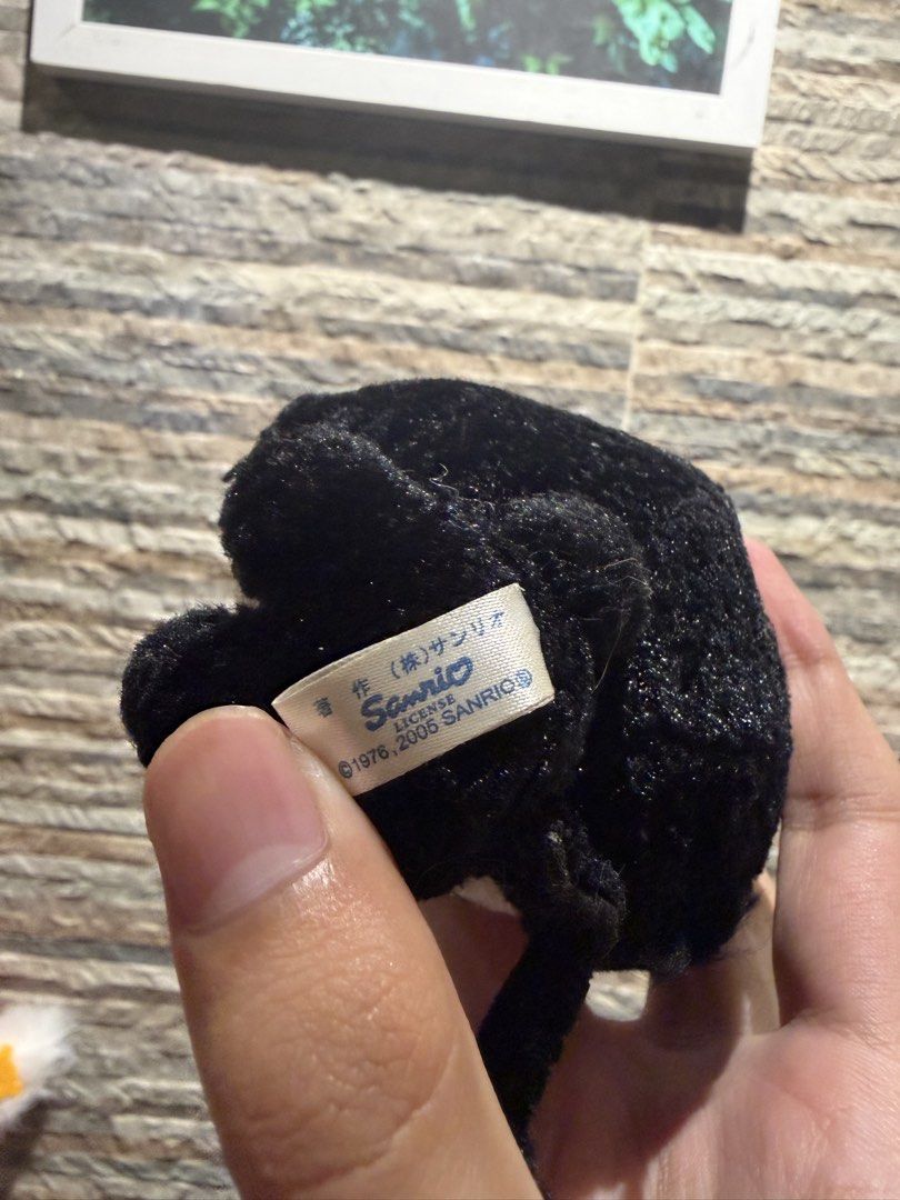 Sanrio Hello Kitty Black Cat Plush Keychain 2005 (Category: Plushies & Soft Toys) located in Makati City. Submitted by squishycorner (Listing ID 1458408758, Image 3). Description: - Adorable Kitty plush keychain - Dressed as a black cat with a purple bow and yellow beak - Authentic Sanrio merchandise from 2005 - Features a metal chain for easy attachment to bags or keys - A must-have for any Kitty enthusiast!.