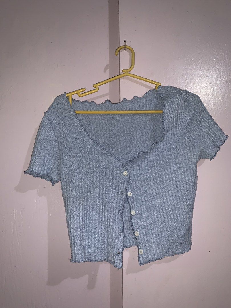 SHEIN Blue Ribbed Button-Up Lettuce Hem Crop Top (Category: Shirts) located in Manila. Submitted by darlynicole (Listing ID 1458407614, Image 1). Description: - Cute light blue ribbed crop top from SHEIN - Features a button-up front - Lettuce hem details on short sleeves and hem - V-neckline - Easy to style with high-waisted jeans or skirts for a casual outfit.