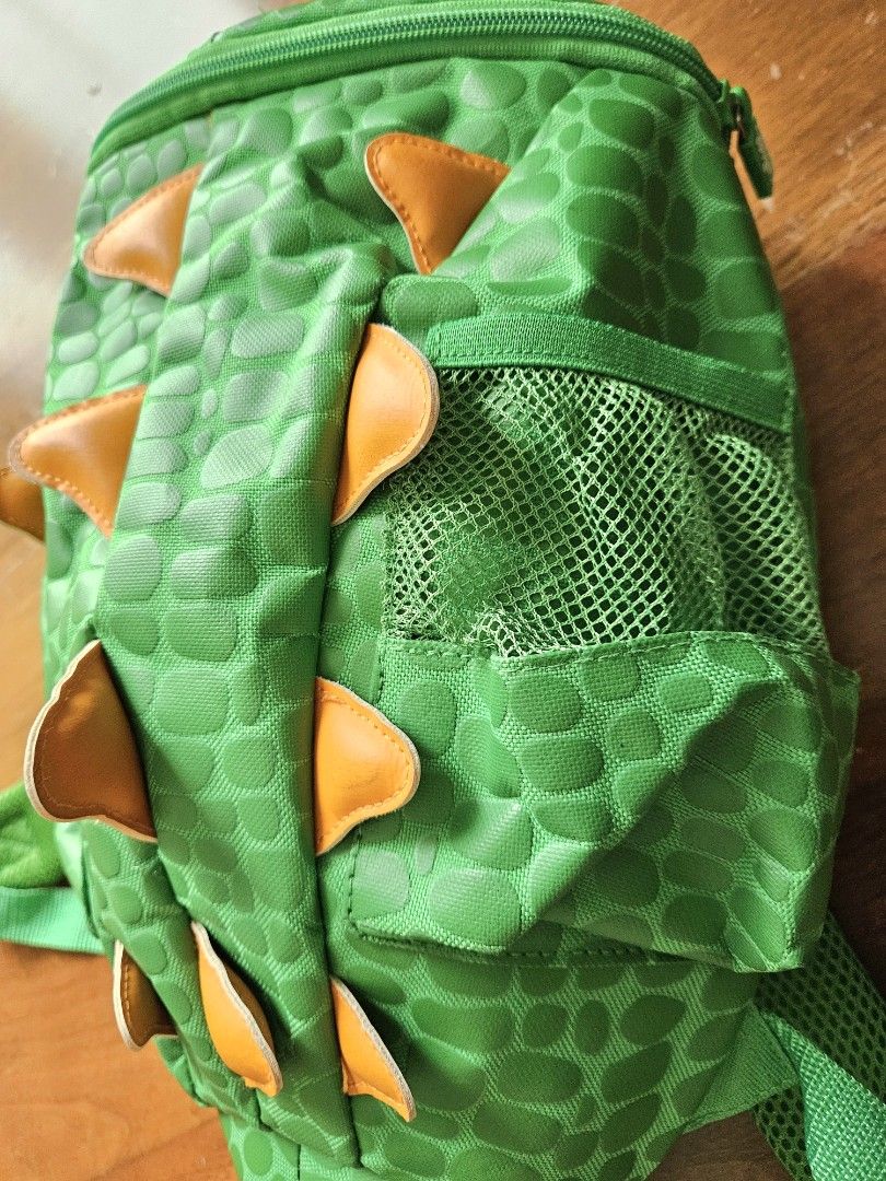 Smiggles Green Dinosaur Backpack (Category: Babies & Kids Fashion) located in Quezon City. Submitted by cristinahorsburgh (Listing ID 1458320956, Image 2). Description: - Adorable Smiggle backpack for kids - Fun dinosaur design with spikes and textured scales - Vibrant bright green color - Convenient side mesh pockets for water bottles - Comfortable padded shoulder straps - Ideal for school, daycare, or day trips - Your child will absolutely love