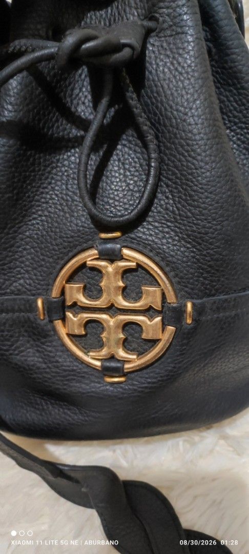 Tory Burch bucket bag (Category: Luxury Bags & Wallets) located in Makati City. Submitted by yerbua103 (Listing ID 1458473971, Image 3). Description: This is amblack pebbled leather TB Miller bucket bag featuring a prominent gold-tone double T logo on the front. Interior is a slip pocket with embossed of Tory Burch New York. It has a dual strap, it can worn as a hand bag or shoulder bag and has a black braided strap for cross-body or worn as a sh