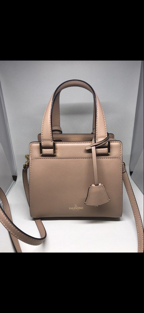Valentino Garavani Rockstud Small Top Handle Bag (Category: Luxury Bags & Wallets) located in Muntinlupa City. Submitted by everythingmustgo_8475da (Listing ID 1458454129, Image 1). Description: - Valentino Garavani small top handle bag - Chic nude pink color - Elegant gold hardware - Detachable shoulder strap for versatile wear - Ideal for everyday or special events .