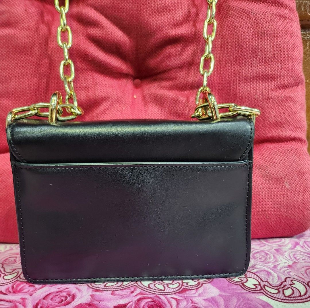 Versace Jeans Couture Black Chain Shoulder Bag (Category: Luxury Bags & Wallets) located in Baguio. Submitted by analon (Listing ID 1458427232, Image 3). Description: - Versace Jeans Couture black shoulder bag - Eye-catching colorful patterned front panel - Chunky gold chain strap for a glamorous touch - Plain black back - Ideal for nights out or elevating your style - Dimensions: Approx. X" wide x Y" tall -kasya phone -dm for more details .