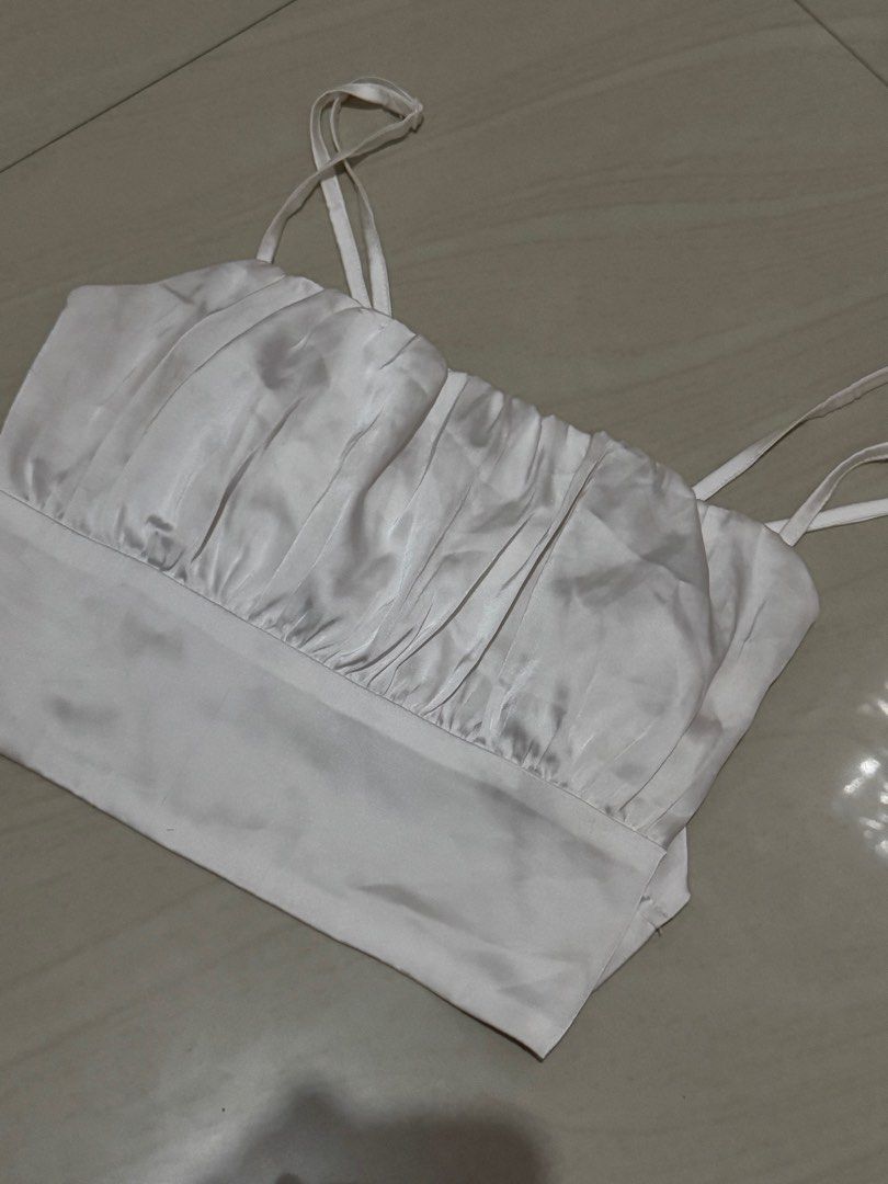 White Ruched Camisole Spaghetti Strap Crop Top (Category: Sleeveless) located in Las Pinas. Submitted by st4rbeam (Listing ID 1458469465, Image 1). Description: - White camisole crop top - Ruched bust detail - Delicate spaghetti straps - Fabric with a subtle sheen - Versatile, pairs well with high-waisted bottoms - Simple and chic design.