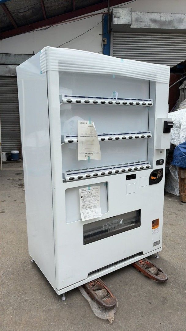 White Vending Machine - Beverage Dispenser (Category: Refrigerators and Freezers) located in Manila. Submitted by silentturtle.e8012b (Listing ID 1458351900, Image 3). Description: - White vending machine - Multiple shelves for drinks - Features coin slot and dispensing area - Ideal for business or large events - Wrapped in plastic, ready for transport or storage - Feel free to ask questions!.