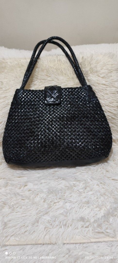 Woven Black Leather Bag (Category: Shoulder Bags) located in Makati City. Submitted by yerbua103 (Listing ID 1458440795, Image 1). Description: This is a black woven leather shoulder bag featuring a structured semi-trapezoid body, dual braided top handles and a snap-tab closure. interior has a middle magnetic compartment, 2-wide side zip and open pockets that can carry your daily essentials. Manage your expectations as you're buying a preloved/uk