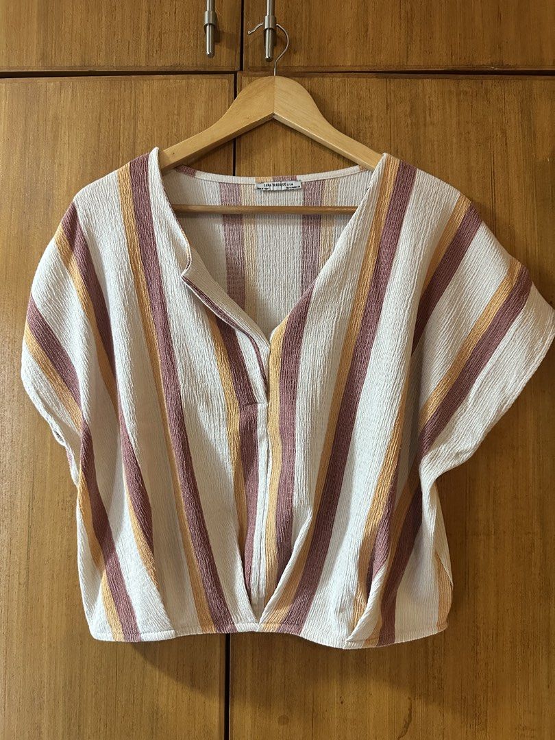 ZARA TRF Striped Twist Front V-Neck Top (Category: Blouses) located in Pasig City. Submitted by zelinavillaflor (Listing ID 1458356117, Image 1). Description: - ZARA TRF striped top - V-neck with button closure - Twist front detail at the hem - Short sleeves - Textured fabric - Ideal for casual wear.