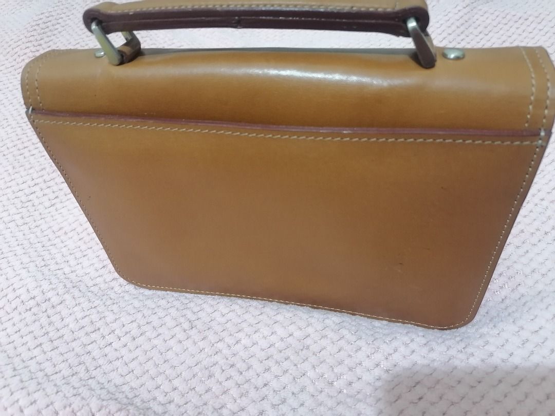 andre valentino (Category: Luxury Bags & Wallets) located in Paranaque City. Submitted by neveahthrift (Listing ID 1453584375, Image 2). Description: Brand: Andre Valentino (Established since 1996)Item Type: Vintage Structured Organizer Bag / Top-Handle ClutchEstimated Production Era: Late 1990s to Early 2000s (Based on the signature minimalist typography stamp and the vintage frame build)Material: Authentic, premium vegetable-tanned smooth tan/c