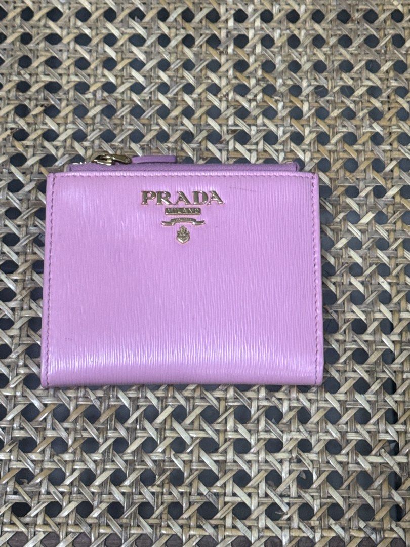 [AUTHENTIC] Prada Pink Bi-Fold Wallet (Category: Luxury Bags & Wallets) located in Santa Rosa. Submitted by rjaarmblo (Listing ID 1453562704, Image 1). Description: - Authentic Prada wallet - Lovely pink shade - Made in Italy - Multiple card slots - Zip compartment - Gold-tone hardware - Great for organizing essentials - Clean interior - Flaws: Has pen marks outside and a bit of dirt. See photos - Original color of wallet are photos 3 and 4.
