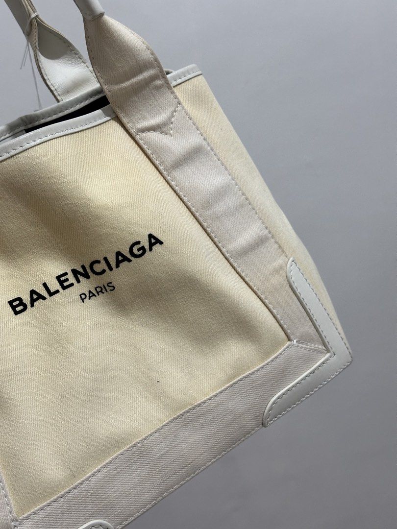 Balenciaga Paris Canvas Tote Bag (Category: Luxury Bags & Wallets) located in Cavite. Submitted by aljennaaaa (Listing ID 1453613932, Image 3). Description: - Brand: Balenciaga - Type: Tote Bag - Color: Cream canvas with white leather trim - Design: Black Balenciaga Paris logo on the front - Features: Top handles, spacious interior - Ideal for: Everyday use, travel - Style: Classic Balenciaga piece.