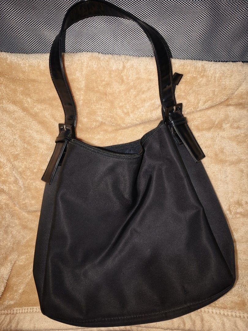 Black Nylon Shoulder Bag with Patent Straps (Category: Shoulder Bags) located in Tanza. Submitted by declutterolshoppe (Listing ID 1453528199, Image 1). Description: - Classic black shoulder bag - Durable nylon material - Shiny patent leather straps - Secure zipper closure - Interior zippered pocket - Ideal for everyday use - Simple and functional design.