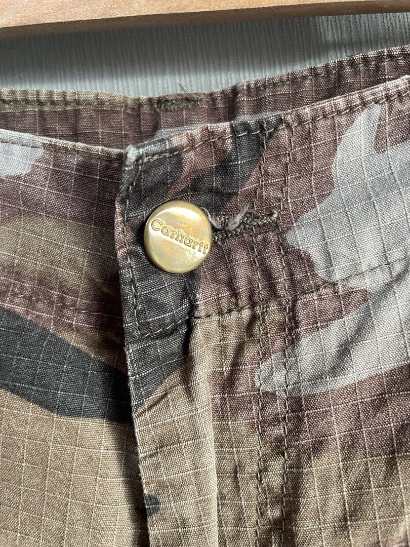 Carhartt Camo Cargo Pants (Category: Jeans) located in Mataasnakahoy. Submitted by zero4thrift (Listing ID 1453525752, Image 2). Description: - Classic Carhartt cargo pants - Brown camouflage pattern - Multiple pockets for ample storage - Button fly closure - Drawstrings at the ankle - Ideal for everyday wear, outdoor activities, or work.