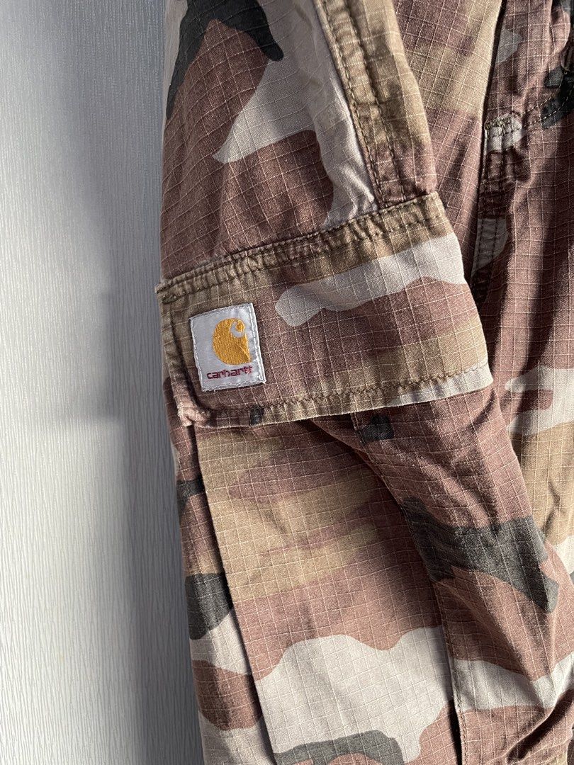 Carhartt Camo Cargo Pants (Category: Jeans) located in Mataasnakahoy. Submitted by zero4thrift (Listing ID 1453525752, Image 3). Description: - Classic Carhartt cargo pants - Brown camouflage pattern - Multiple pockets for ample storage - Button fly closure - Drawstrings at the ankle - Ideal for everyday wear, outdoor activities, or work.