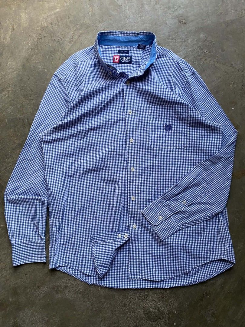Chaps Easy Care Gingham Button Down Shirt (Category: Tshirts & Polo Shirts ) located in Cabanatuan. Submitted by vivian_nicole_03 (Listing ID 1453535791, Image 1). Description: - Classic blue and white gingham pattern - Brand: Chaps - Style: Button-down shirt - Neckline: Collared - Closure: Button - Features: Chest pocket with embroidered Chaps logo - Fabric: Easy care, suitable for everyday wear - Size: Medium (M).