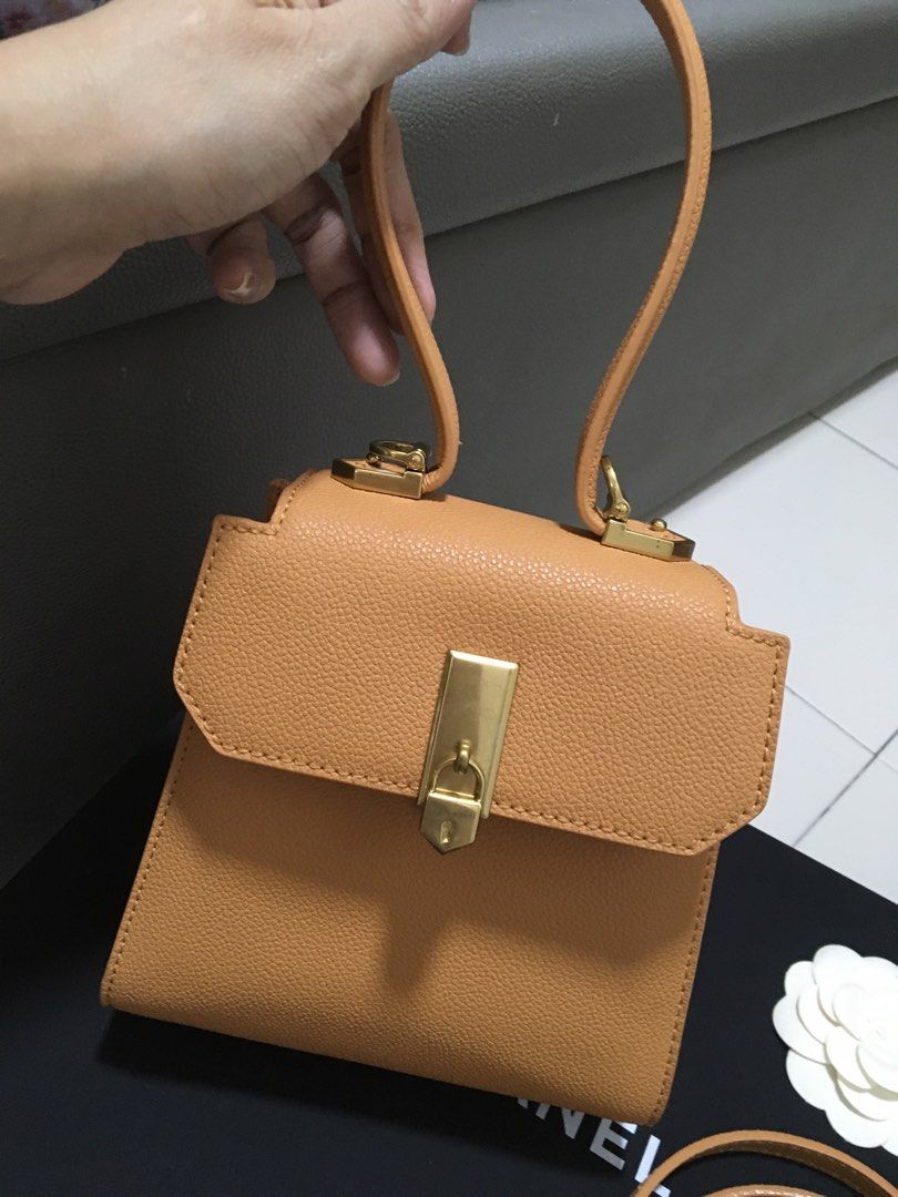 Charles & Keith Tan Top Handle Bag with Sling Strap (Category: Cross-body Bags) located in Quezon City. Submitted by simple_precious (Listing ID 1453475304, Image 2). Description: - Brand: Charles & Keith - Color: Tan - Style: Top handle bag - Features: Detachable sling strap, gold hardware, secure clasp closure - Includes: Original dust bag - Versatile: Suitable for everyday or special occasions Never used.
