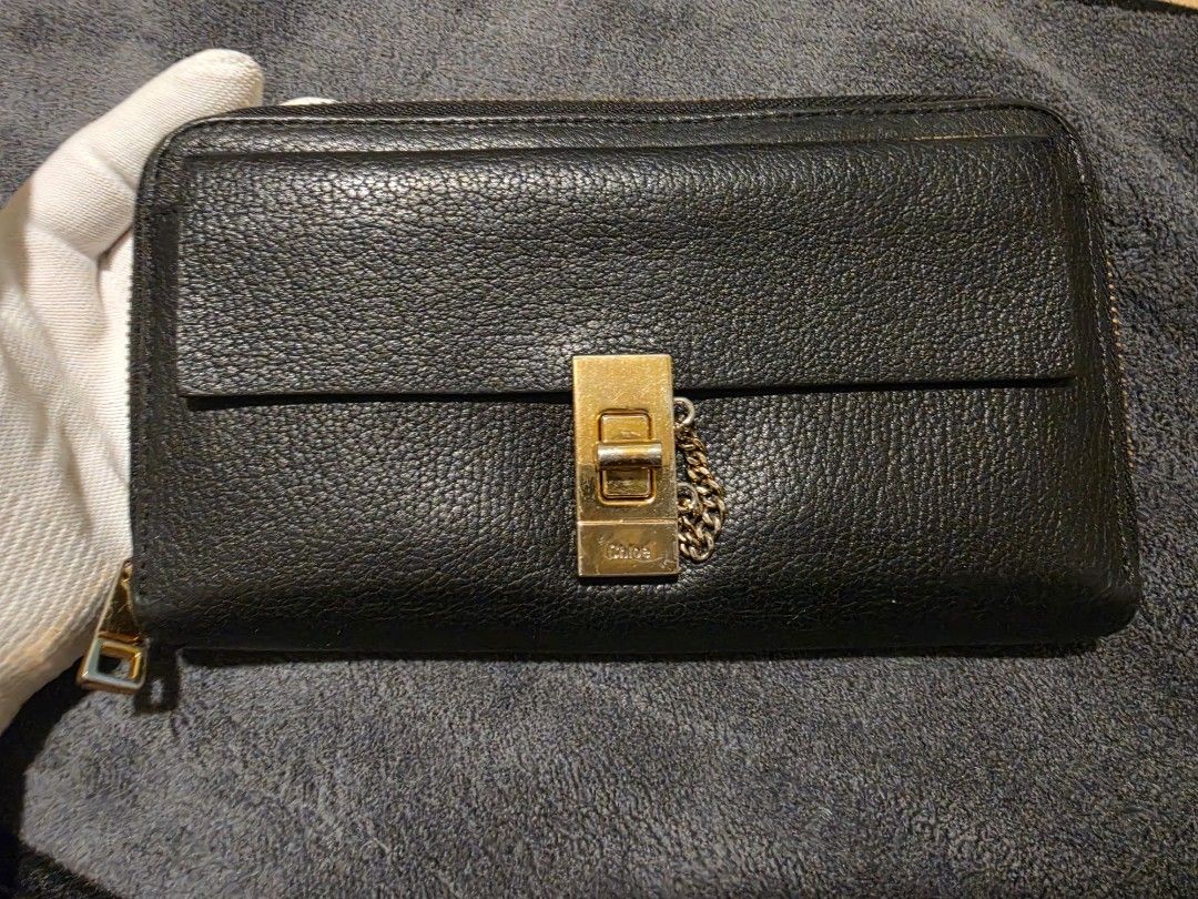 Chloe Black Leather Long Wallet with Gold Clasp (Category: Wallets & Card holders) located in Makati City. Submitted by bagattic_etc (Listing ID 1453431661, Image 1). Description: Brand: Chloé Model: Likely Elsie Zip-Around Continental Wallet Material: Pebbled calfskin leather Color: Black Hardware: Gold-tone turn-lock with decorative chain Made in Spain Zip-around closure for added security Front flap pocket with the iconic Elsie lock Multiple c