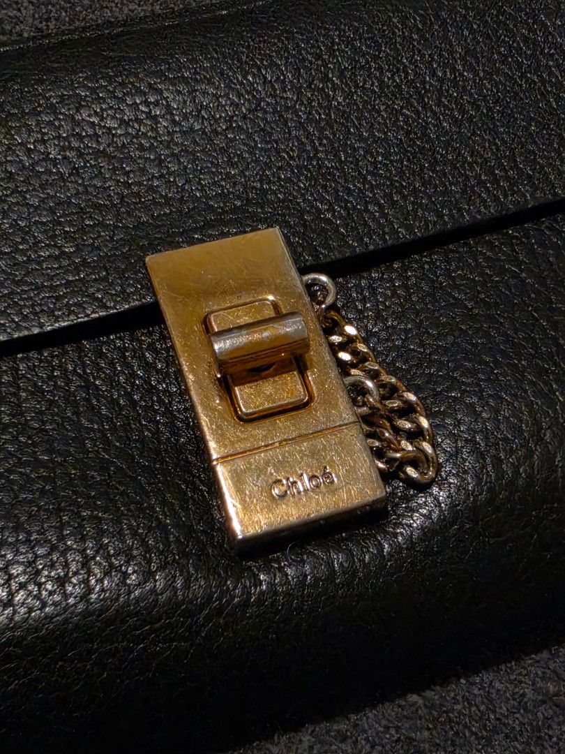 Chloe Black Leather Long Wallet with Gold Clasp (Category: Wallets & Card holders) located in Makati City. Submitted by bagattic_etc (Listing ID 1453431661, Image 2). Description: Brand: Chloé Model: Likely Elsie Zip-Around Continental Wallet Material: Pebbled calfskin leather Color: Black Hardware: Gold-tone turn-lock with decorative chain Made in Spain Zip-around closure for added security Front flap pocket with the iconic Elsie lock Multiple c