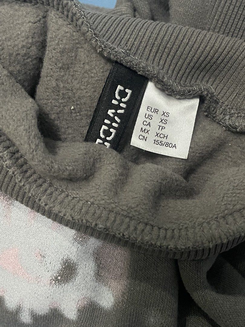 Divided Grey Cropped Sweatshirt with Graffiti Print (Category: Longsleeves) located in Marikina City. Submitted by flutterchi (Listing ID 1453584234, Image 2). Description: - Grey cropped sweatshirt from Divided - Features a graffiti-style print with pink and white details - Mock neck and long sleeves - Raw hem for a trendy look - Super cropped fit, perfect with high-waisted bottoms.