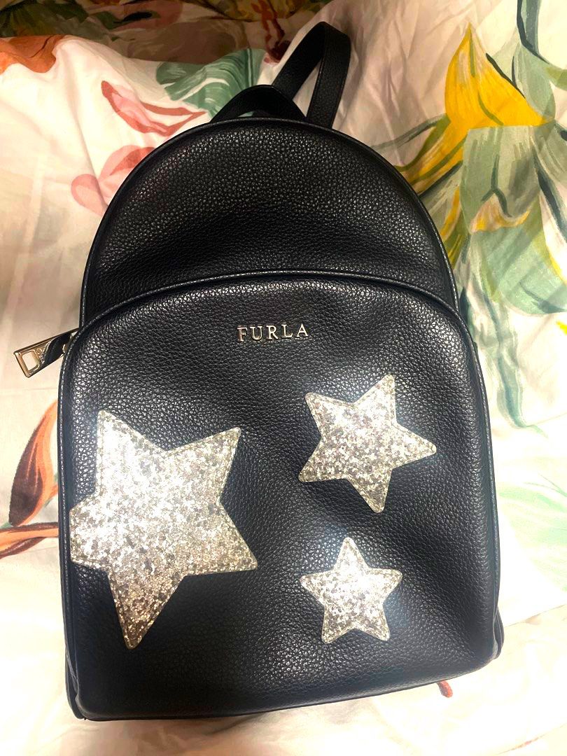 Furla Black Leather Backpack with Glitter Stars (Category: Backpacks) located in Pasig City. Submitted by treefairyapple (Listing ID 1453551269, Image 1). Description: - Cute Furla backpack in black pebbled leather - Features sparkly glitter star embellishments on the front - Zip closure - Interior zip pocket and Furla logo tag - Padded back with adjustable straps - Great for everyday use or a fun night out.
