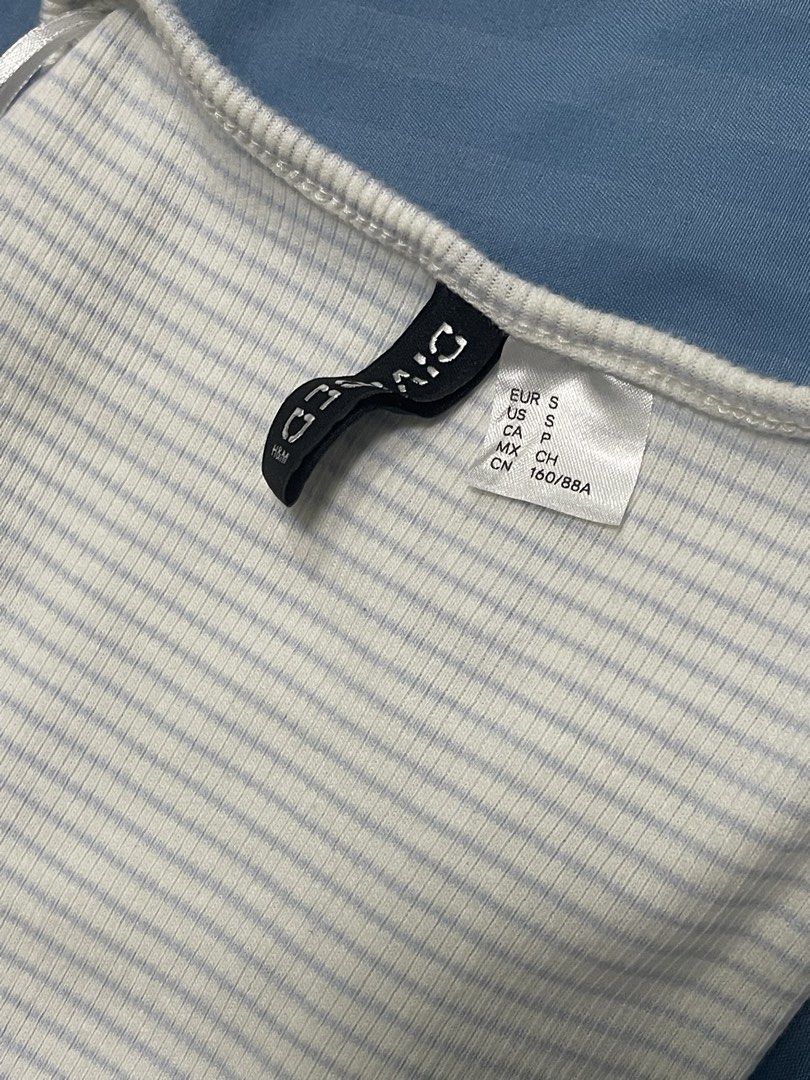 H&M Divided Ribbed Square Neck Top White Blue Stripes Size S (Category: Sleeveless) located in Marikina City. Submitted by flutterchi (Listing ID 1453584009, Image 2). Description: - White ribbed top with subtle thin blue stripes - Flattering square neckline with a sweet front bow detail - Comfortable short cap sleeves - Stretchy material for a great fit - Brand: H&M Divided - rfs: not my style anymore.