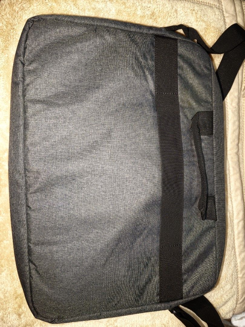 HP Laptop Bag Messenger Bag (Category: Sling Bags) located in Tanza. Submitted by declutterolshoppe (Listing ID 1453534411, Image 2). Description: - Grey HP laptop bag - Top handle and shoulder strap for versatile carrying - Front zip pocket for quick access to essentials - Back strap to secure onto luggage - Ample interior space for laptop and accessories.