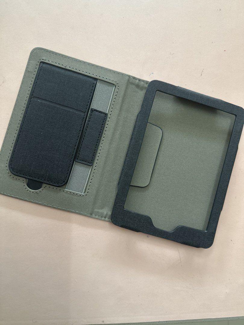 Kindle Basic 11th gen Dark Grey Folio Case for Tablet with Stand (Category: Cases & Sleeves) located in Davao. Submitted by mblee322 (Listing ID 1453434501, Image 2). Description: - Dark grey folio case for tablets - Built-in stand for hands-free viewing - Interior card slots - Secure device holder - Magnetic clasp closure - Protects against scratches and bumps - Perfect for travel or everyday use.
