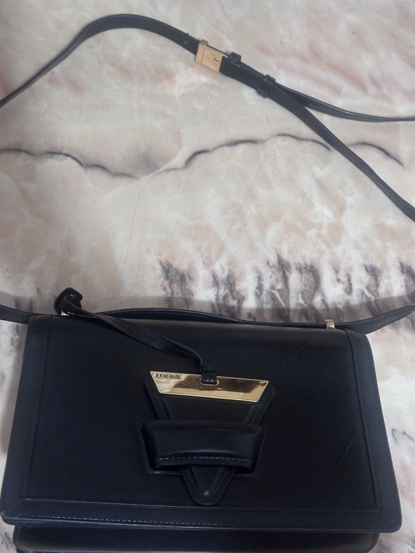 Loewe Black Leather Shoulder Bag with Gold Accent (Category: Luxury Bags & Wallets) located in Manila. Submitted by skylerslove (Listing ID 1453583601, Image 2). Description: - Authentic Loewe black leather shoulder bag - Iconic gold-tone Anagram clasp - Interior zipped pocket and card slots - Made in Spain - Clean interior and exterior - Adjustable strap.