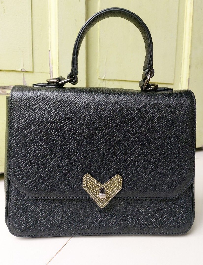Lovcat Paris Top handle bag with Heart Clasp (Category: Luxury Bags & Wallets) located in Lapu Lapu. Submitted by agnesapm_29813 (Listing ID 1453563709, Image 2). Description: - Black textured leather handbag - Cute heart-shaped clasp with rhinestones - Top handle for carrying - Simple and chic design - Versatile: good for everyday or special occasions - Clean interior - Measurements: width-8.5 inches, height-6.5 inches.