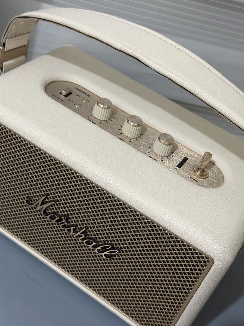 Marshall Kilburn III (Category: Soundbars, Speakers & Amplifiers) located in Quezon City. Submitted by annpy (Listing ID 1453583109, Image 3). Description: - Cream colored Marshall Kilburn III speaker - Portable design with a comfortable leather handle - Easy-to-use controls on top: volume, bass, and treble - Convenient aux input and USB charging port - Delivers impressive sound quality for its compact size - Ideal for enjoying music on the go Co