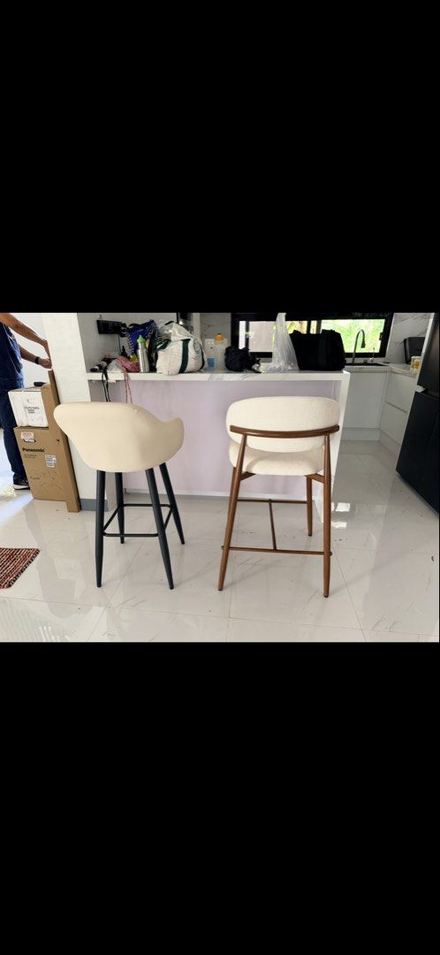 Modern Bar Stools - Cream Upholstery (Category: Chairs) located in Pasig City. Submitted by mbbproperties (Listing ID 1453619451, Image 1). Description: - Set of 2 bar stools - One stool with black metal legs - One stool with wooden legs - Both stools feature cream-colored upholstered seats - Ideal for kitchen islands or bar counters - Sold as a pair - Ready for a new home.