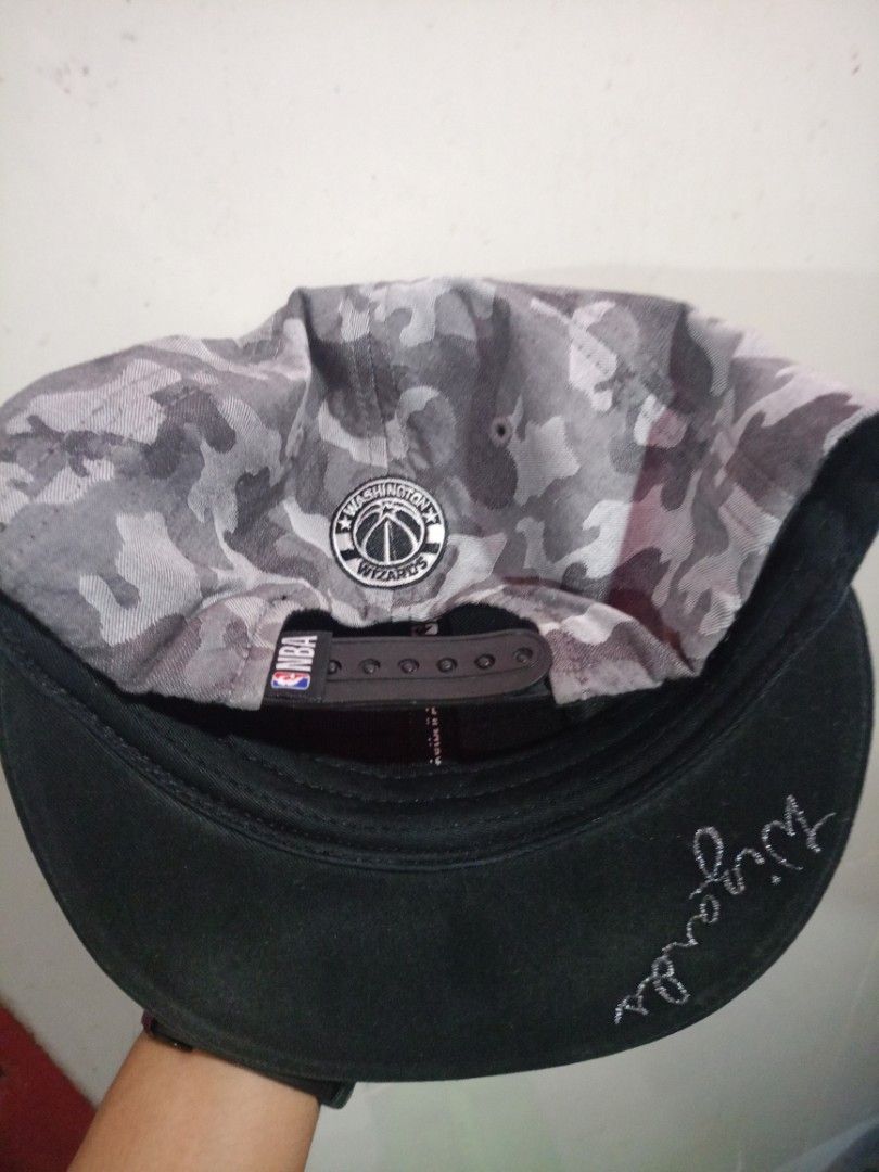 NBA Washington Wizards Camo License Plate Cap (Category: Caps & Hats) located in Manila. Submitted by gengthrift_84 (Listing ID 1453606423, Image 3). Description: NBA Logo-Printed Seam Tapes: Ang mga panloob na tahi (seam lines) ay natatakpan ng tela na may malinaw, pantay, at sunod-sunod na "NBA National Basketball Association" text at trademark logo.Eastern Conference at Official NBA Tags: May nakadikit na high-quality woven labels sa bandang s