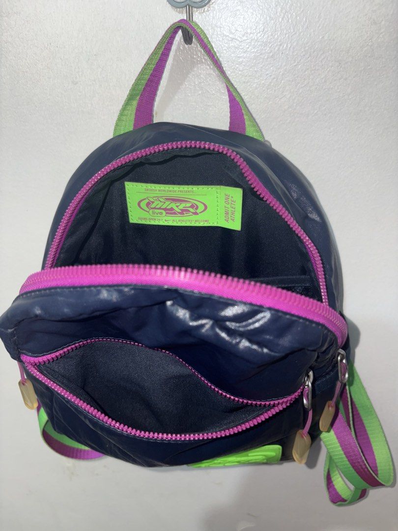 Nike Mini Backpack Navy Blue & Neon Green (Category: Backpacks) located in Apalit. Submitted by trishy.stuff (Listing ID 1453436115, Image 3). Description: - Cute mini backpack from Nike - Color: Navy blue with neon green and purple straps - only issue see the last photo ( zipper color little faded and yellowish nike bling) - Original price: 2499 - Selling price: 1200 - rfs: no longer need it and need funds.